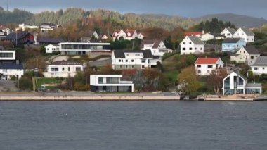 Norveç 'te gezinti. Bottan fiyordun manzarası, tekneden dağların manzarası, şelaleler, yolcu gemileri ve hassas tekneler turistleri gemiden kıyıya taşıyan mavi gökyüzü ile güzel bir günde