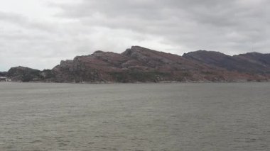 Norveç 'te gezinti. Bottan fiyordun manzarası, tekneden dağların manzarası, şelaleler, yolcu gemileri ve hassas tekneler turistleri gemiden kıyıya taşıyan mavi gökyüzü ile güzel bir günde