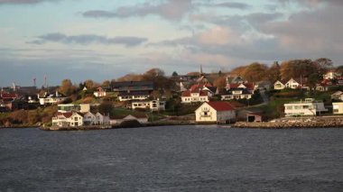 Norveç 'te gezinti. Bottan fiyordun manzarası, tekneden dağların manzarası, şelaleler, yolcu gemileri ve hassas tekneler turistleri gemiden kıyıya taşıyan mavi gökyüzü ile güzel bir günde