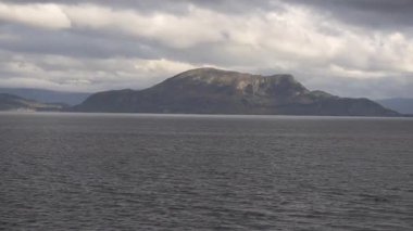 Norveç 'te gezinti. Bottan fiyordun manzarası, tekneden dağların manzarası, şelaleler, yolcu gemileri ve hassas tekneler turistleri gemiden kıyıya taşıyan mavi gökyüzü ile güzel bir günde