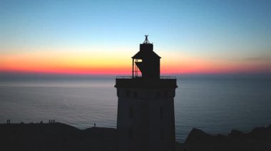 Tepenin tepesinde ünlü deniz feneri olan dev kum tepelerinin hava manzarası. Rubjerg Knude Deniz Feneri, Kuzey Deniz Rubjerg, Danimarka Lokken yakınlarındaki Rubjerg Knude Fyr deniz fenerinde gün batımı. 