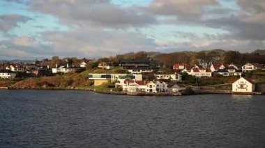 Norveç 'te gezinti. Bottan fiyordun manzarası, tekneden dağların manzarası, şelaleler, yolcu gemileri ve hassas tekneler turistleri gemiden kıyıya taşıyan mavi gökyüzü ile güzel bir günde