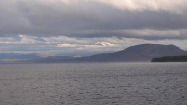 Norveç 'te gezinti. Bottan fiyordun manzarası, tekneden dağların manzarası, şelaleler, yolcu gemileri ve hassas tekneler turistleri gemiden kıyıya taşıyan mavi gökyüzü ile güzel bir günde