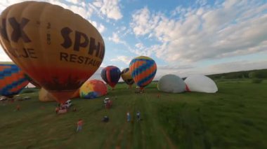 Kyiv, Ukrayna - 05.23.2021: İnsanlarla açık havada sıcak hava balonları. Hava manzaralı arka planda renkli balonlar. Yaz tatili. Sıcak hava balonu sabah uçuyor..