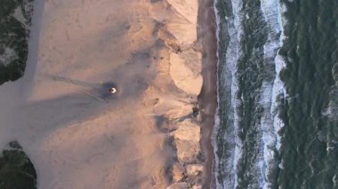 Tepenin tepesinde ünlü deniz feneri olan dev kum tepelerinin hava manzarası. Rubjerg Knude Deniz Feneri, Kuzey Deniz Rubjerg, Danimarka Lokken yakınlarındaki Rubjerg Knude Fyr deniz fenerinde gün batımı. 