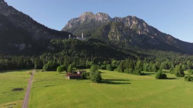 Bavyera Alpleri, Almanya 'daki Neuschwanstein Şatosu, Yaz manzarası - Bavyera Alpleri' ndeki ünlü turistik cazibe manzarası - 19. yüzyıl Neuschwanstein şatosu yeşil dağlar arasında. 