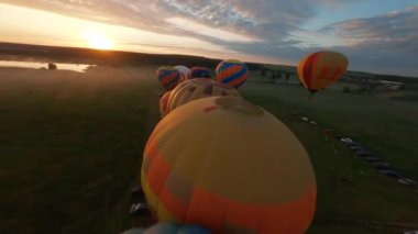 Kyiv, Ukrayna - 05.23.2021: İnsanlarla açık havada sıcak hava balonları. Hava manzaralı arka planda renkli balonlar. Yaz tatili. Sıcak hava balonu sabah uçuyor..