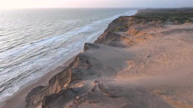 Tepenin tepesinde ünlü deniz feneri olan dev kum tepelerinin hava manzarası. Rubjerg Knude Deniz Feneri, Kuzey Deniz Rubjerg, Danimarka Lokken yakınlarındaki Rubjerg Knude Fyr deniz fenerinde gün batımı. 