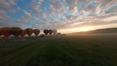 Kyiv, Ukrayna - 05.23.2021: İnsanlarla açık havada sıcak hava balonları. Hava manzaralı arka planda renkli balonlar. Yaz tatili. Sıcak hava balonu sabah uçuyor..