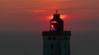 Tepenin tepesinde ünlü deniz feneri olan dev kum tepelerinin hava manzarası. Rubjerg Knude Deniz Feneri, Kuzey Deniz Rubjerg, Danimarka Lokken yakınlarındaki Rubjerg Knude Fyr deniz fenerinde gün batımı. 
