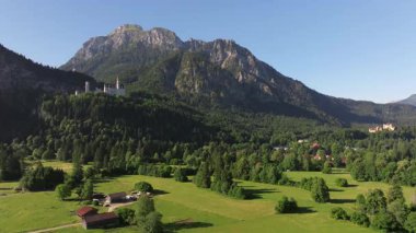 Bavyera Alpleri, Almanya 'daki Neuschwanstein Şatosu, Yaz manzarası - Bavyera Alpleri' ndeki ünlü turistik cazibe manzarası - 19. yüzyıl Neuschwanstein şatosu yeşil dağlar arasında. 