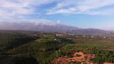 Yunanistan 'daki Girit adasının Dağ Havası manzarası. Gün batımında dağ manzarası, zeytin ağaçları ve üzüm bağları. Güney Ege Denizi üzerinde uçan hava videosu Oia, Santorini, Yunanistan, gün doğumunu gösteriyor