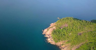 Günbatımında, Endonezya, Bali 'de, turkuaz dalgalı bir deniz tarafından yıkanan güzel adanın göz kamaştırıcı manzarası. Endonezya 'da yaz günü mavi gökyüzünün altındaki dağlara karşı plantasyonlar