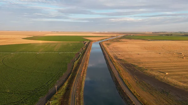 Drone view during sunrise over a farm hay field and river in Alberta Canada. High quality Drone footage