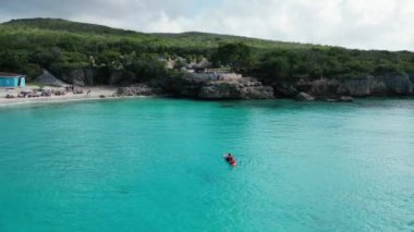 Aerial drone footage over Playa Porto Marie in West Punt Curaca. Carribean beach drop down footage over the clear sea and sand. High quality 4k footage