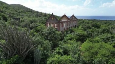 Landuis Newtown Jeremi Curacao. Eski Manganez maden depolama binaları terk edilmiş yemyeşil yeşilliklere dönüştü. Yüksek kalite fotoğraf