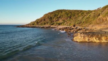 Okyanusa bakan mavi gökyüzü bulutsuz gününde Noosa Ulusal Parkı Queensland Avustralya üzerindeki hava görüntüleri. Yüksek Kalite Video