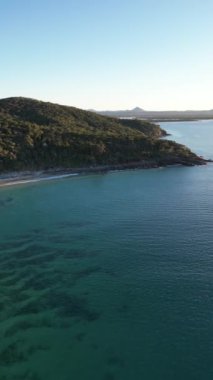 Okyanusa bakan mavi gökyüzü bulutsuz gününde Noosa Ulusal Parkı Queensland Avustralya üzerindeki hava görüntüleri. Yüksek Kalite Video