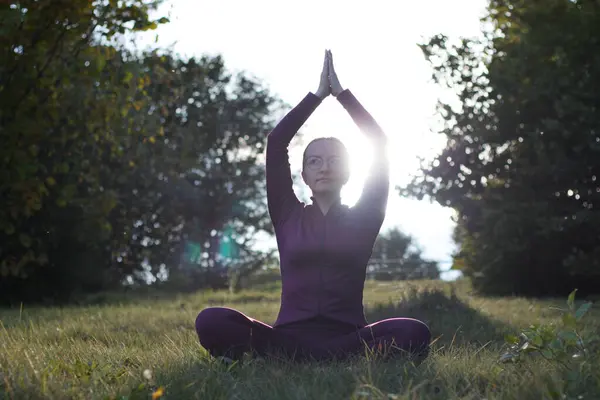 woman practices yoga outdoor in mountain landscape