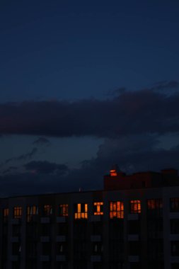 Parlak günbatımı evin pencerelerine yansıyor.