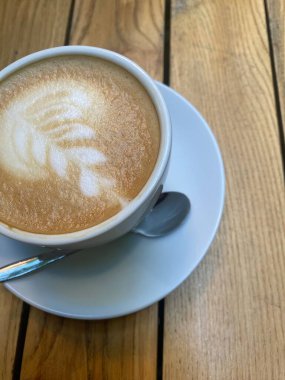 Masanın üzerinde fincan tabağı olan bir fincan kahve.