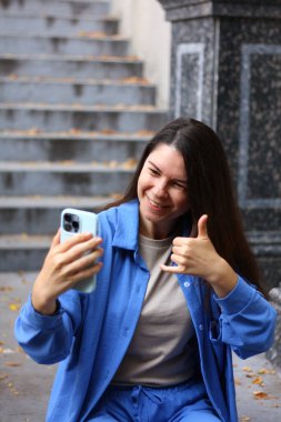 Kadın telefonda fotoğraf çekiyor, selfie çekiyor, bana işaret ver.