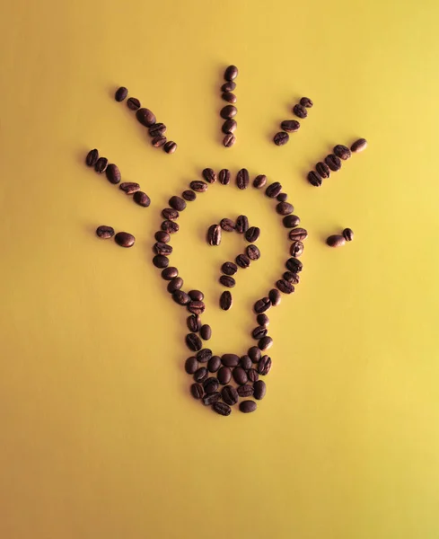 lamp made of coffee beans on a yellow background, morning coffee, wake up, idea