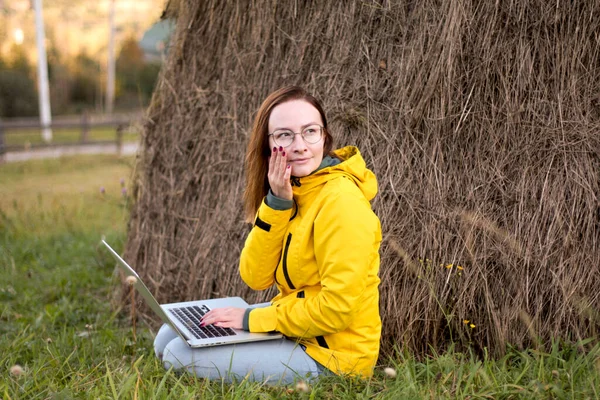 girl works at the laptop in nature