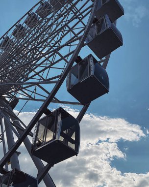 ferris wheel on the background of a blue sky with white clouds