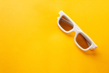 Sarı arka planda 3D beyaz gözlük, film izleriz.