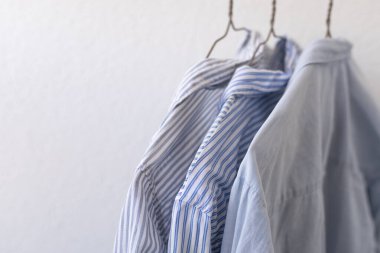 Askıdaki kıyafetler, beyaz arka plandaki boakite gömlekler, alışveriş, kıyafet dolabı.