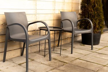 Masa ve sandalyeler bahçede, evin arka bahçesinde.