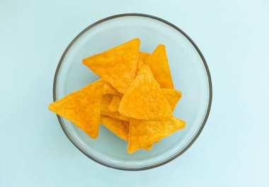 corn chips with cheese in a glass plate, top view