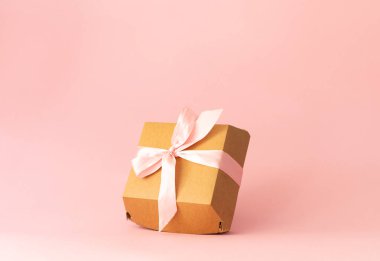 Karton ambalaj, açık pembe arka planda bento keki, açık pembe fiyonk.