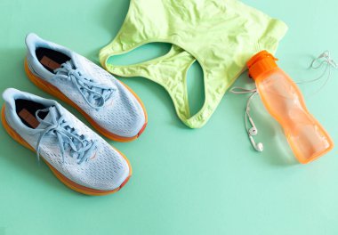Spor giysileri, ayakkabıları, kulaklığı ve su şişesiyle yatıyordu.