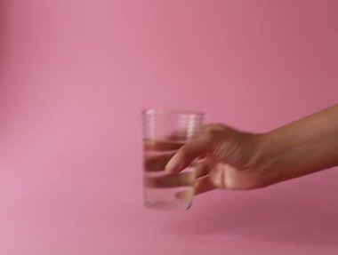 Kadının eli bir bardak su koyuyor.