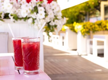 Masadaki kafede iki bardak pembe limonata.