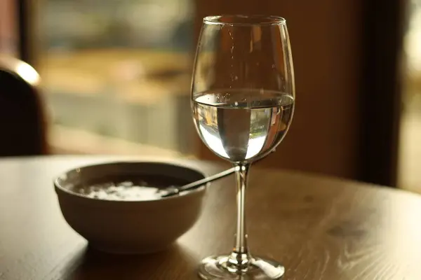 stock image bowl of hot oatmeal and a glass of water on the table