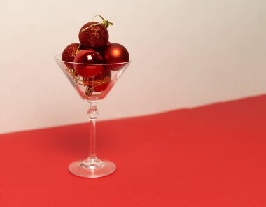 Kırmızı Noel toplarıyla martini bardağı