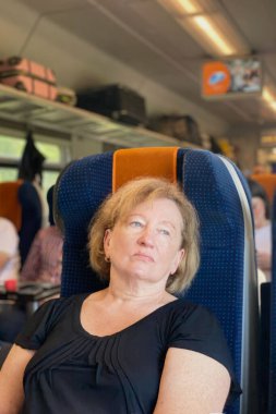 Trendeki yorgun ve yaşlı bir kadının portresi. Seyahat, göç kavramı