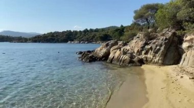 Sakin dalgalar, körfezin kumlu sahilini, seyahat ve dinlenme konseptini bulur.