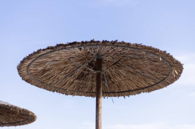 Sahilde saman şemsiyeler. Yaklaş.