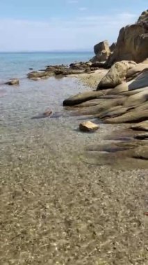 Kayanın yanındaki temiz deniz suyu, ufuk çizgisi.