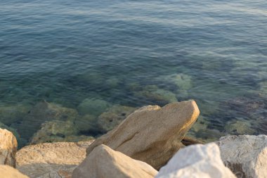 Deniz koylarında mavi suyu olan büyük taş katmanları.