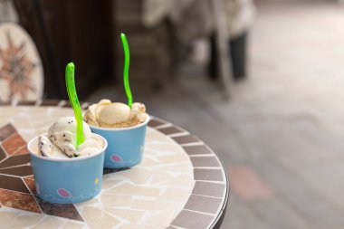 Dışarıdaki bir kafede masanın üzerinde karton bardaklarda iki porsiyon dondurma.