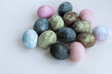 Yeşil-kahverengi renklerde boyanmış dört Paskalya yumurtası, Karkade çayı, yumuşak pastel renkler.