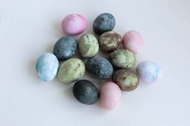 Yeşil-kahverengi renklere boyanmış dört Paskalya yumurtası, Karkade çayı, yumuşak pastel renkler, arka plan