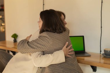 successful project, two women were working at computers and joyfully hugging clipart