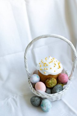 Paskalya pastası ve beyaz hasır sepetinde Paskalya yumurtası.