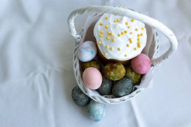 Paskalya pastası ve beyaz hasır sepetinde Paskalya yumurtası.